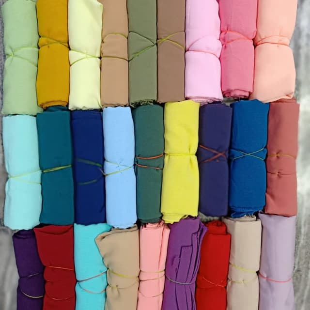 A wide variety of solid colors including greens, yellows, blues, pinks, purples, and neutrals. Hijabs