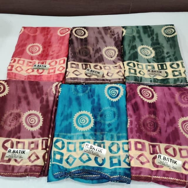 Various shades including pink, brown, green, blue, and purple with cream and off-white accents. Saree