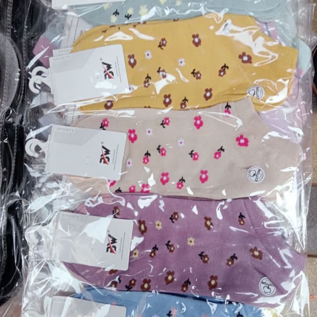 Various pastel colors including yellow, beige, lavender, and blue, with floral accents in brown, pink, and white. Socks