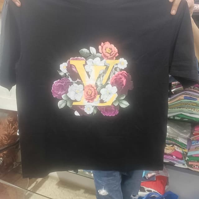 Black, with a floral print in shades of pink, peach, white, green, and yellow. T-shirt
