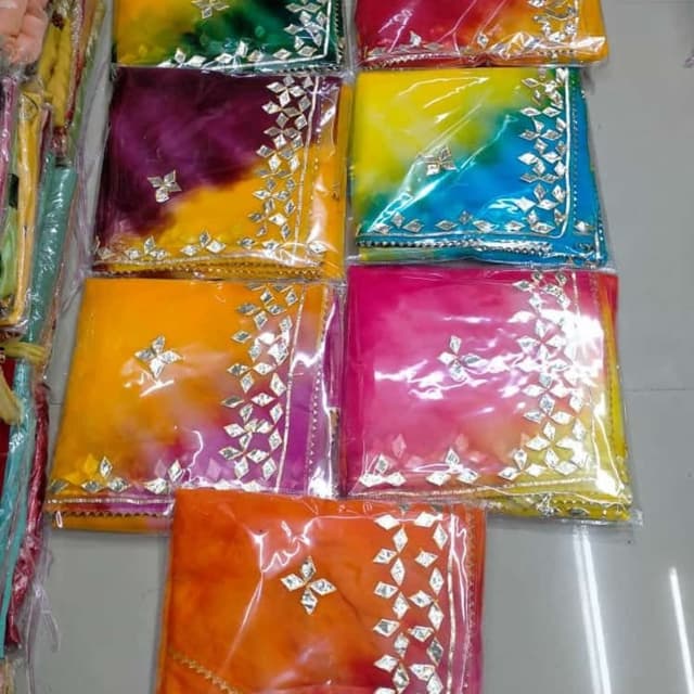 Vibrant and multi-colored, with tie-dye effects including shades of yellow, orange, pink, purple, blue, green and red. Saree