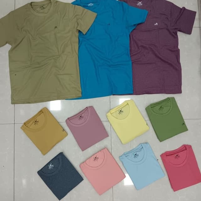 Various solid colors including olive green, teal, purple, mustard yellow, dusty rose, sunshine yellow, forest green, charcoal gray, light pink, sky blue, and coral T-shirt