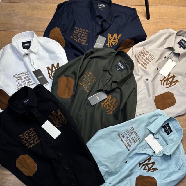 Various, including white, black, navy, olive green, light blue, and beige. Brown patches and embroidery. Shirt