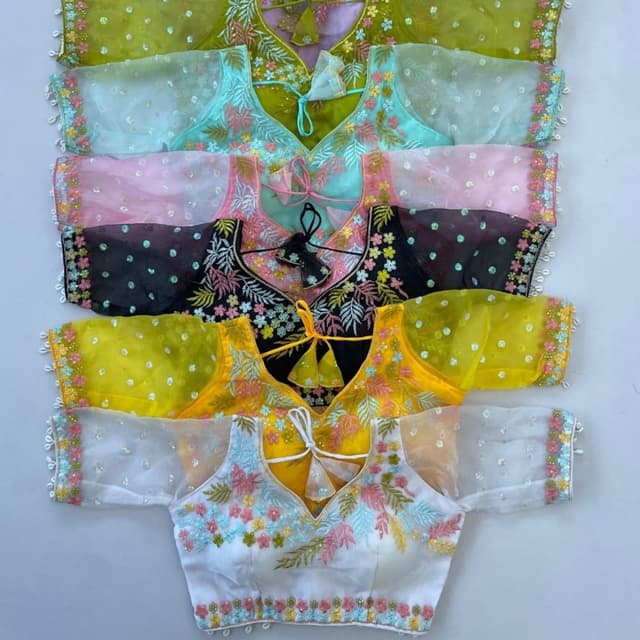 Various, including white, yellow, black, pink, blue, and green, each with coordinating embroidery. Blouses