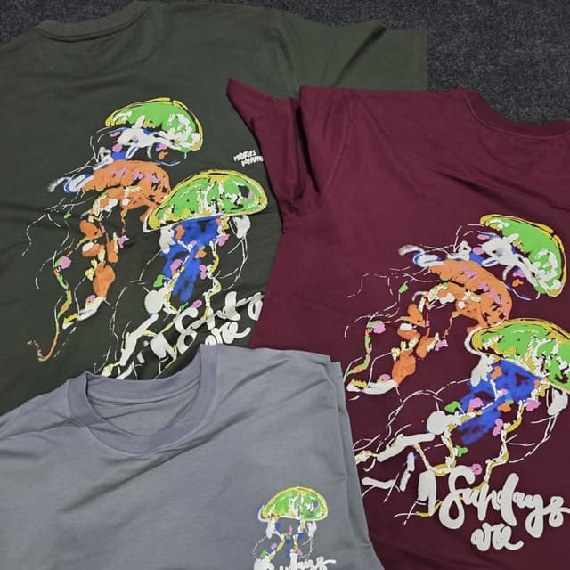 Various, including olive green, burgundy, and gray, with a vibrant jellyfish print incorporating green, orange, blue, and white. T-shirt