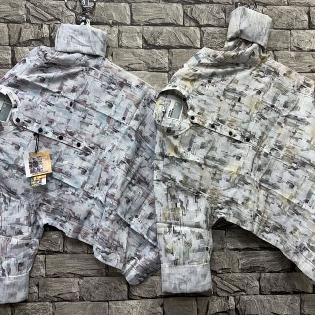 Cool-toned with shades of gray, white, and hints of muted blue, green, and brown. Shirt