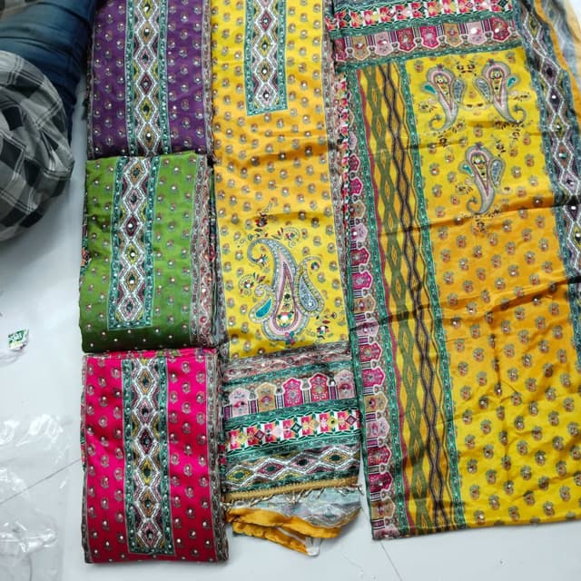 Vibrant and diverse, with primary colors like yellow, green, purple, and pink, accented with multi-colored patterns Unstitched Suit Set or Dress Material