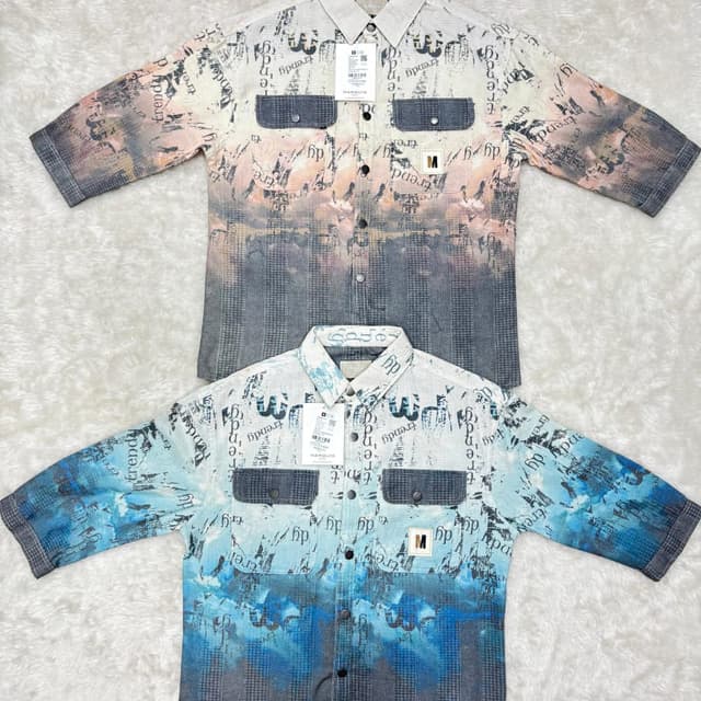 The shirts feature a gradient color scheme, with the top one transitioning from a pale peach to gray and the bottom one from white to shades of blue. The background is a mix of colors with texts on them. Shirt