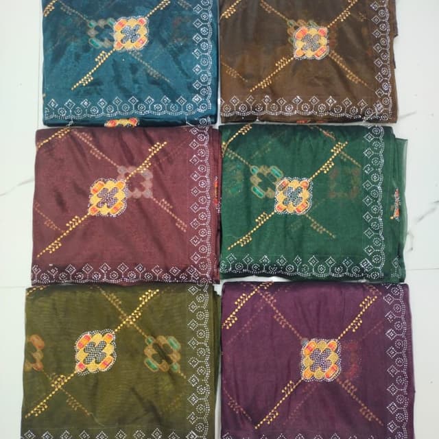 Various jewel tones including teal, brown, burgundy, green, olive, and purple with gold and white accents. Saree