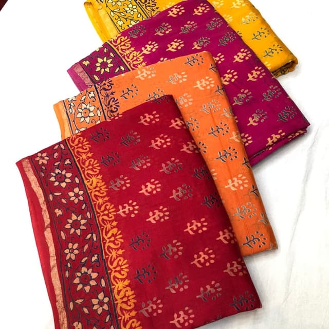 Red, orange, yellow, and magenta, with contrasting floral and leaf prints in complementary colors. Fabric or Textile