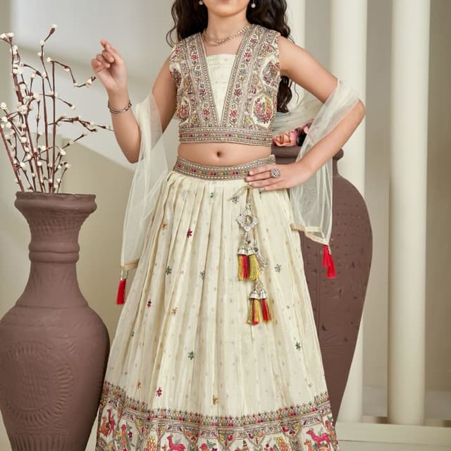 Ivory, with accents of red, yellow, green, and multi-colored embroidery. Lehenga Choli