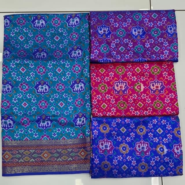 Teal, purple, pink, and blue, with accents of gold and other complementary colors. Saree