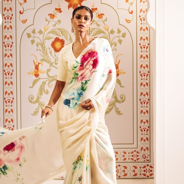 Ivory, with a multicolor floral print in shades of pink, blue, and yellow Saree