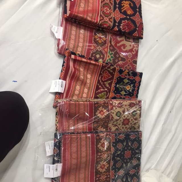 Red, maroon, navy blue, beige, and gold with intricate patterns. Saree