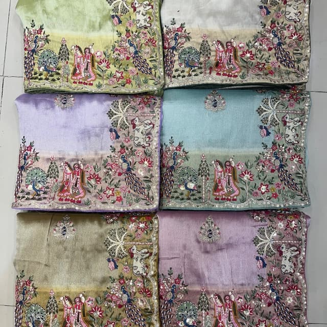 Various pastel shades including light green, silver, lavender, sky blue, and mauve, with multi-colored embroidery. Saree