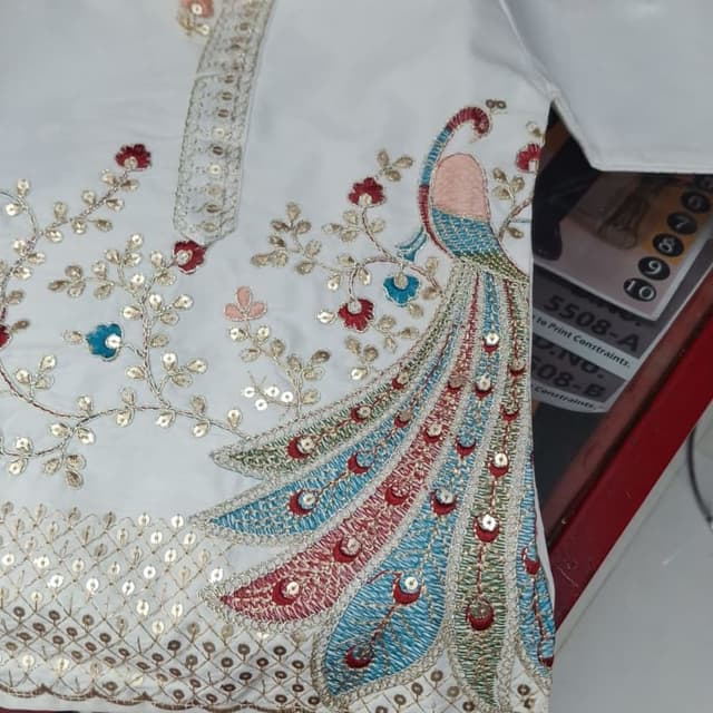 White with a peacock design in shades of blue, red, green, and pink, accented with gold. Kurta (likely a part of a Salwar Kameez suit)