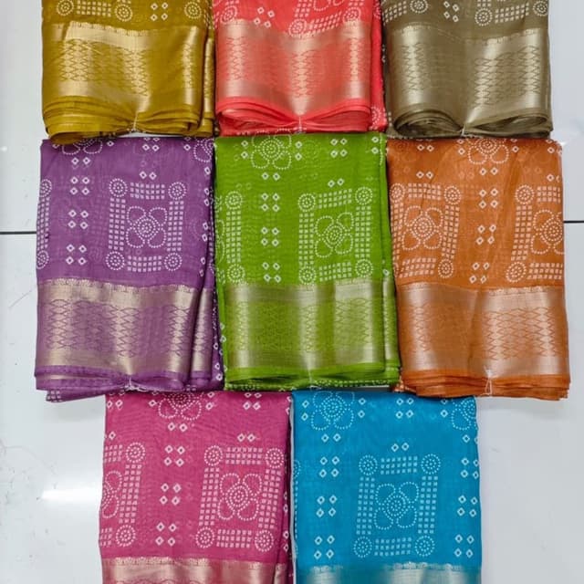 Various vibrant colors including yellow, coral, olive green, purple, green, orange, pink, and blue, with white print and metallic silver borders. Saree