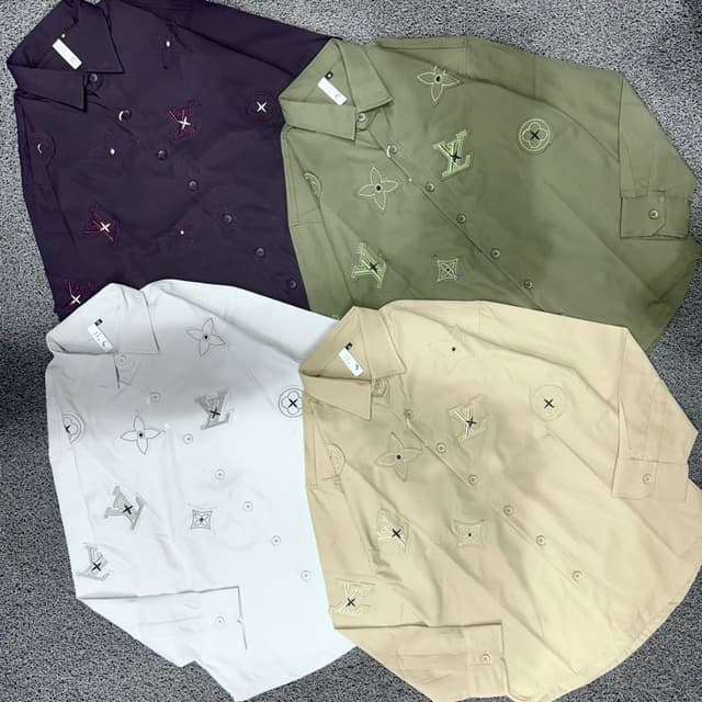 Various, including white, khaki, dark purple, and olive green shirts, each with embroidered embellishments in contrasting colors. Shirts