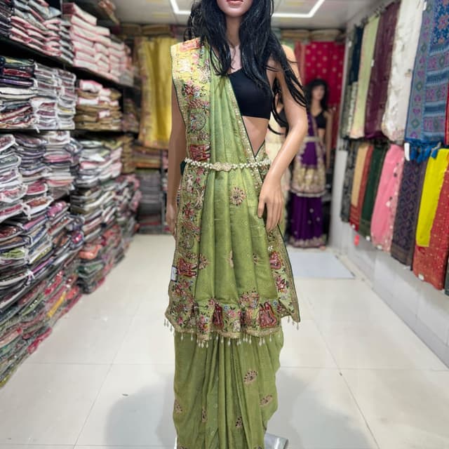 Green, with multi-colored embroidery and embellishments Saree