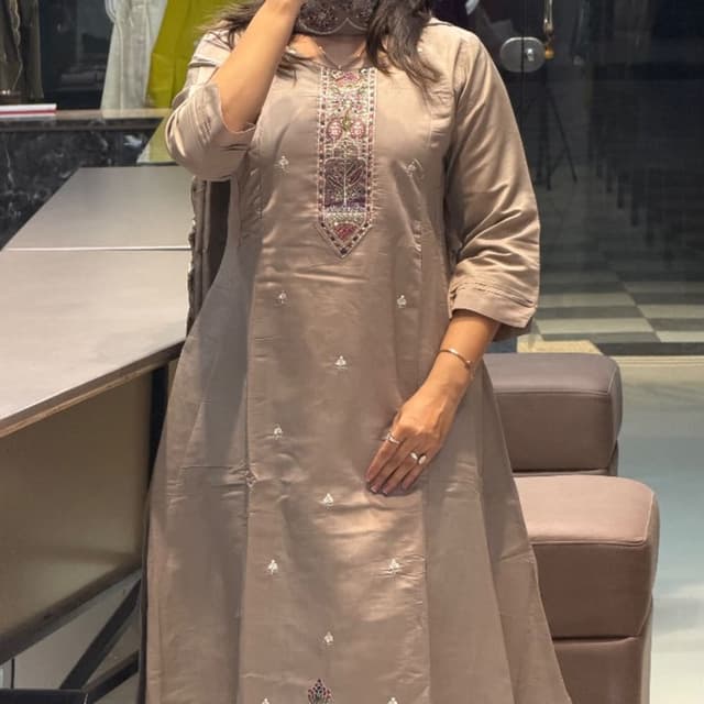 Taupe, with accents of burgundy, green, and pink in the embroidery Kurta with matching trousers and dupatta