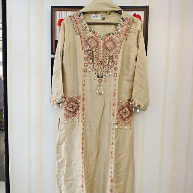 Beige, with accents of red, green, and gold Kurta