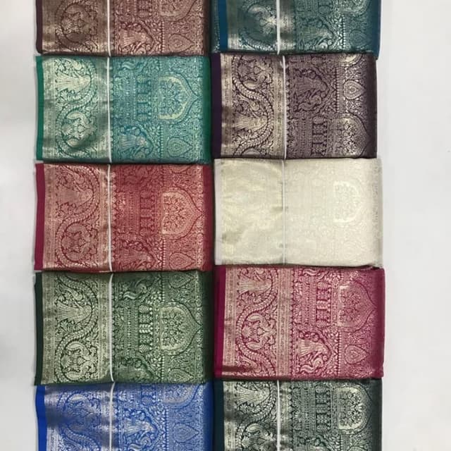 Various, including jewel tones such as burgundy, teal, emerald, and navy, with metallic gold or silver accents. Saree Fabric