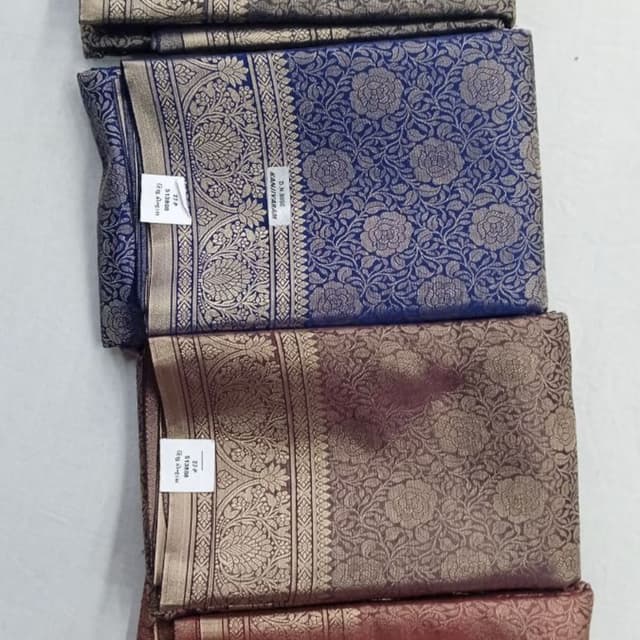Various, including shades of blue, brown, and maroon with gold accents Saree