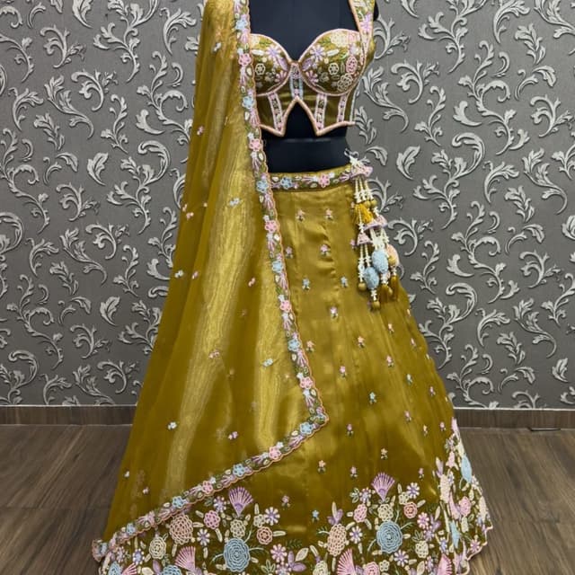 Mustard yellow base with pastel pink, blue, and white floral embroidery Lehenga Choli