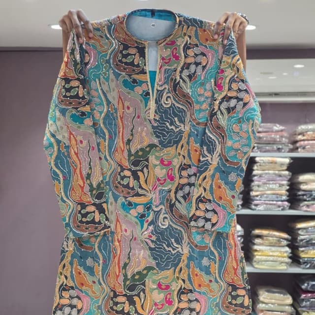Teal base with multi-colored patterns including mustard yellow, pink, olive green, black, and white accents Kurta