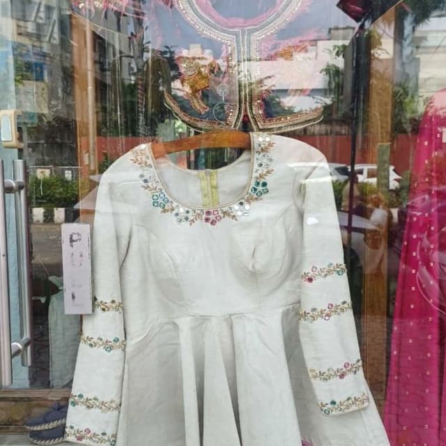 Off-white base with multi-colored floral embroidery and pink piping Peplum Top