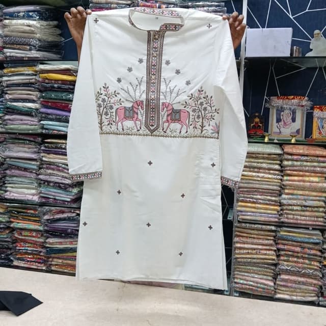 White base with pink, green, and earthy tone embroidery Kurta