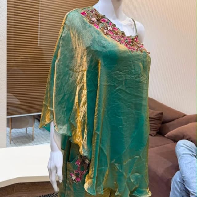 Shimmering emerald green with gold undertones, accented with fuchsia pink and white floral embroidery Co-ord set featuring a cape-style top and wide-leg trousers