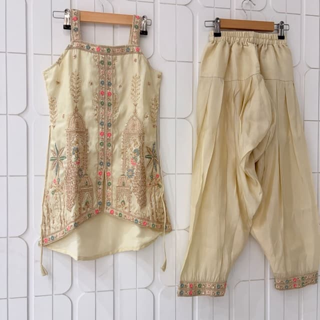 Light cream or off-white base with multi-colored accents including pink, blue, and green Kurti and Dhoti Set