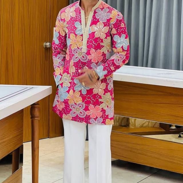 Hot pink base with multi-colored pastel floral patterns in light blue, peach, lavender, and beige, contrasted with white trousers Kurta with Trousers