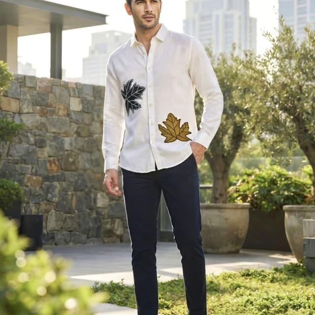 Off-white shirt with black and golden leaf embroidery, paired with navy blue trousers Shirt