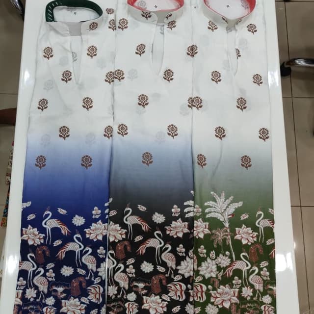 White base with ombre transition to blue, black, or green, featuring brown floral prints and multi-colored nature motifs at the hem Kurti