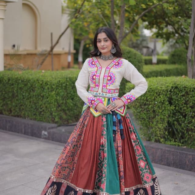 Off-white top with multi-colored embroidery, rust-brown, teal-green, and black skirt Lehenga Choli