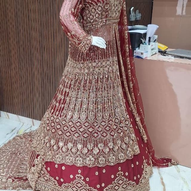 Deep maroon or burgundy with extensive gold metallic embroidery Lehenga Choli with long Anarkali-style jacket