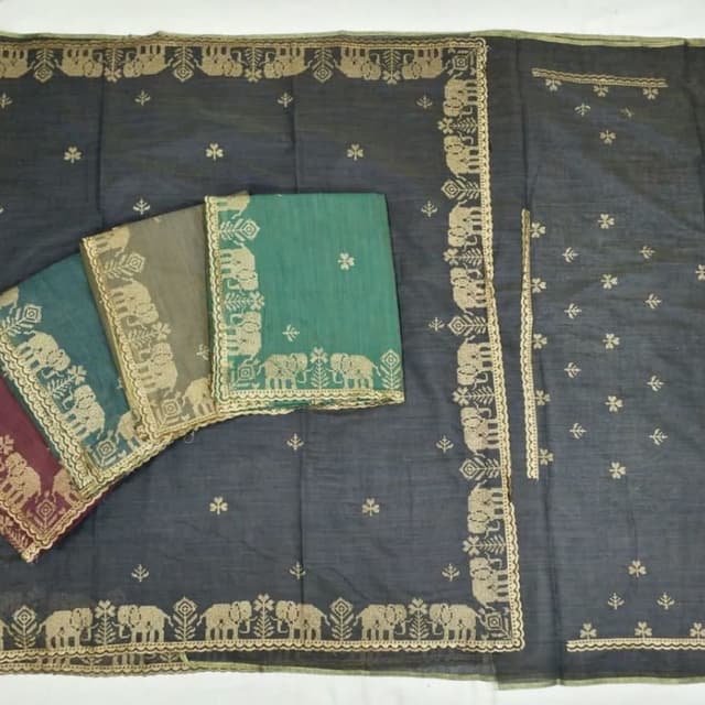 Dark grey/charcoal base with emerald green accents and gold embroidery Saree