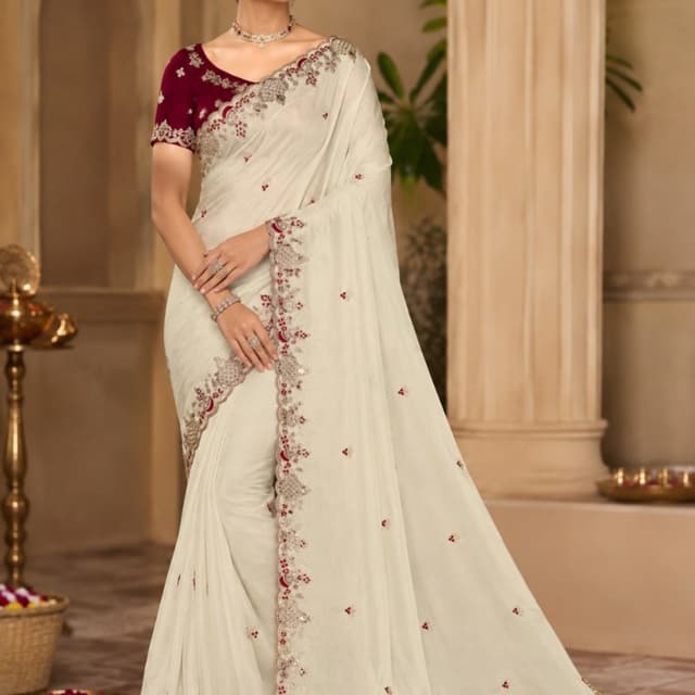 Off-white or cream base with maroon and metallic silver accents Saree