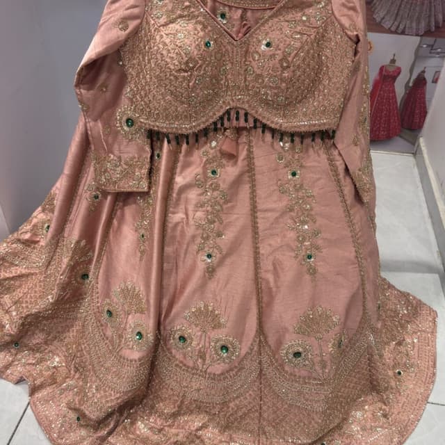 Dusty rose or peach pink with gold embroidery and emerald green stone accents Lehenga Choli