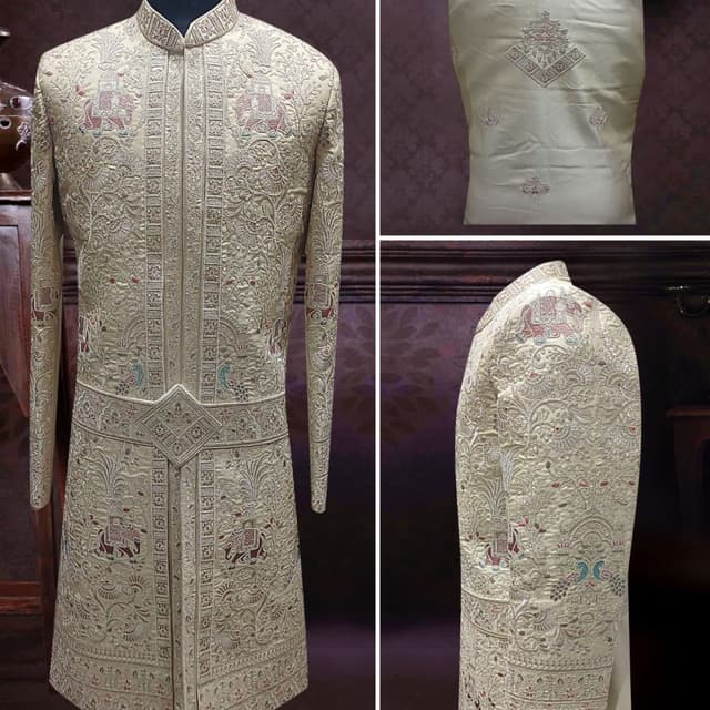 Off-white or cream base with multicolor embroidery including hints of maroon, teal, and gold Sherwani