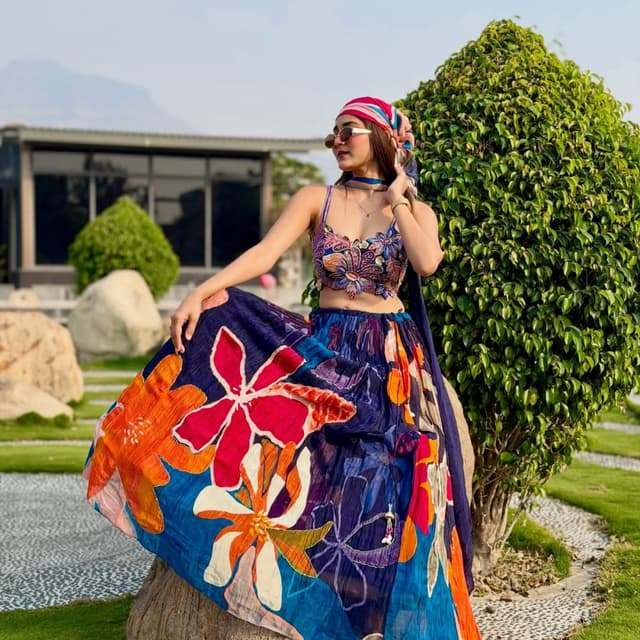 Navy blue base with vibrant multi-colored floral print including pink, orange, white, and teal Lehenga Choli