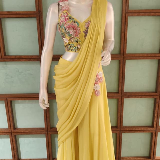 Bright yellow base with floral accents in pink, peach, and white Pre-draped Saree / Saree Gown